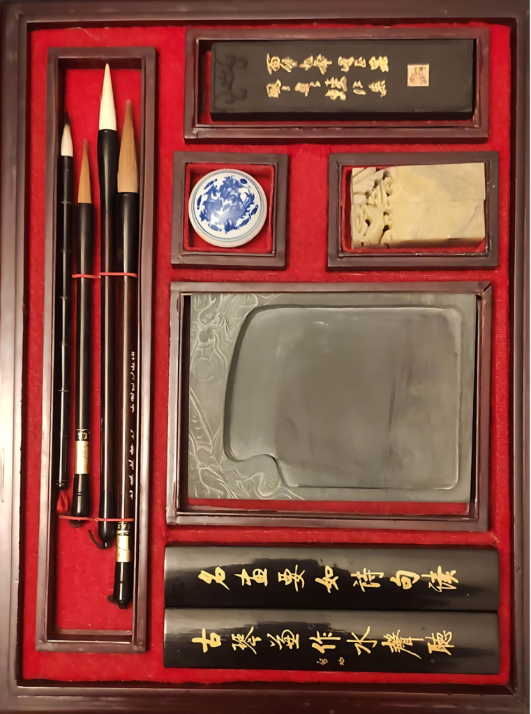 Boite de matériel de calligraphie : 4 pinceaux de poils et de tailles différentes, de l'encre solide, pierre à encre, sceau, pate rouge à sceau et 2 presse-papiers en bois